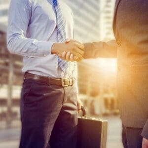 Business handshake between two professionals with briefcase