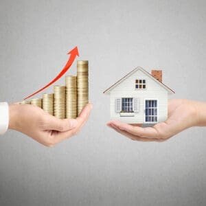 Increasing home value shown by coins and house