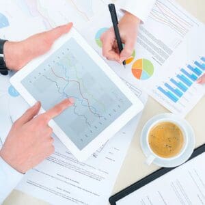 Tablet with charts, documents, pen, and coffee